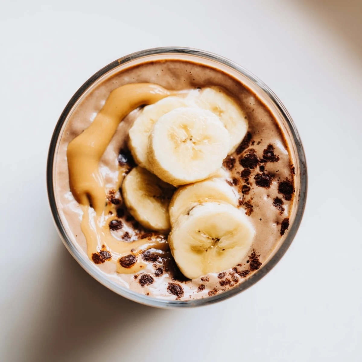 Decadent Chocolate Peanut Butter Smoothie in a frosty glass, garnished with shaved chocolate and a swirl of peanut butter.