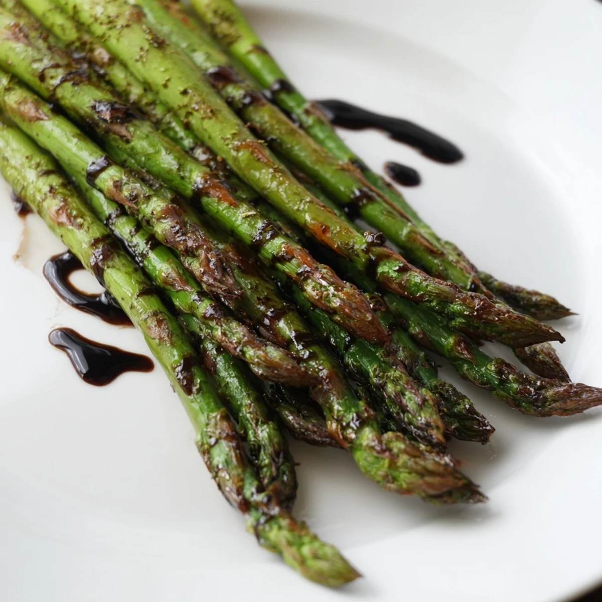 Golden, caramelized Roasted Asparagus with Balsamic Glaze arranged on a parchment-lined baking sheet, drizzled with a glossy, reduced balsamic sauce.