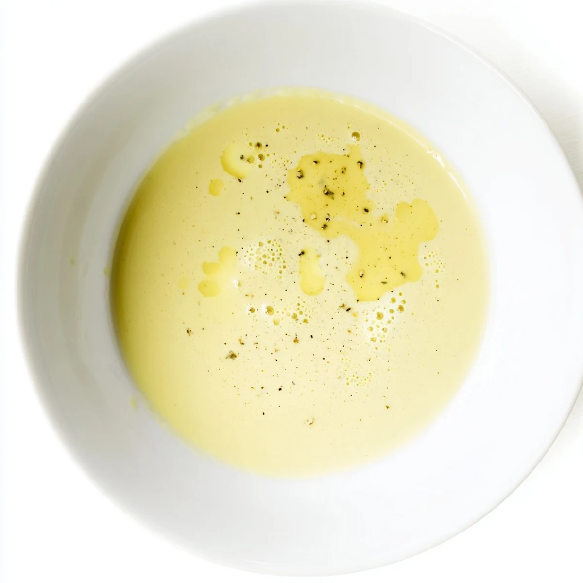 A fresh lemon dijon dressing emulsified in a glass jar, ready to drizzle over a crisp green salad.