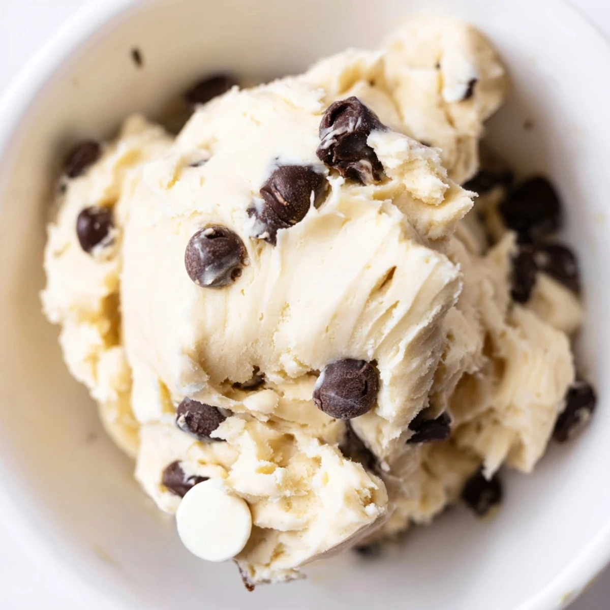 A bowl of Guilt Free Greek Yogurt Cookie Dough topped with dark chocolate chips and chopped walnuts.