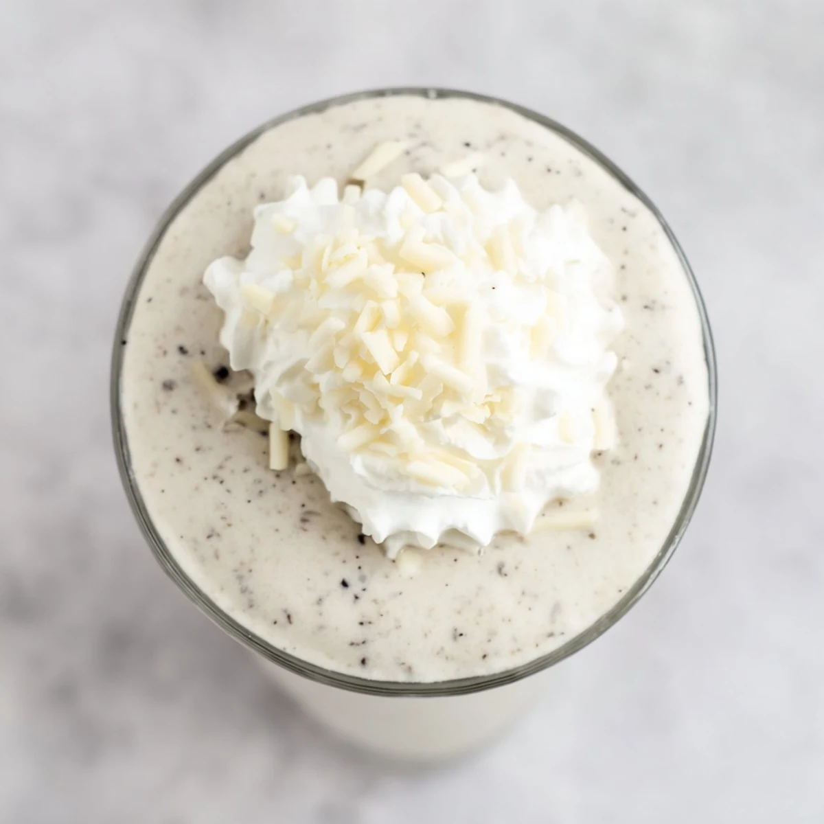 Frothy Vanilla Bean Frappuccino topped with whipped cream in a clear glass, icy and refreshing for summer.