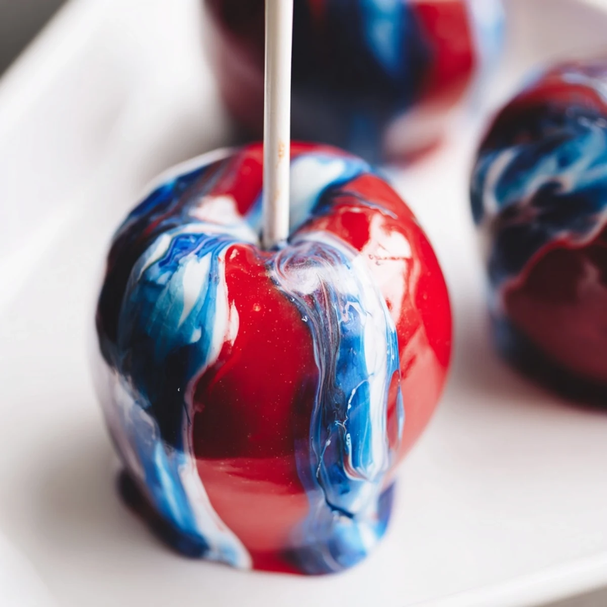 Freshly made Marbled Effect Candy Apples displayed on a wooden board with sugar crystals sparkling.