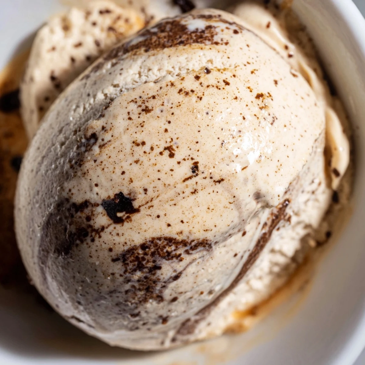 Creamy Vietnamese Coffee Ice Cream in a rustic bowl, topped with crushed ice and a drizzle of sweetened condensed milk for a refreshing dessert.