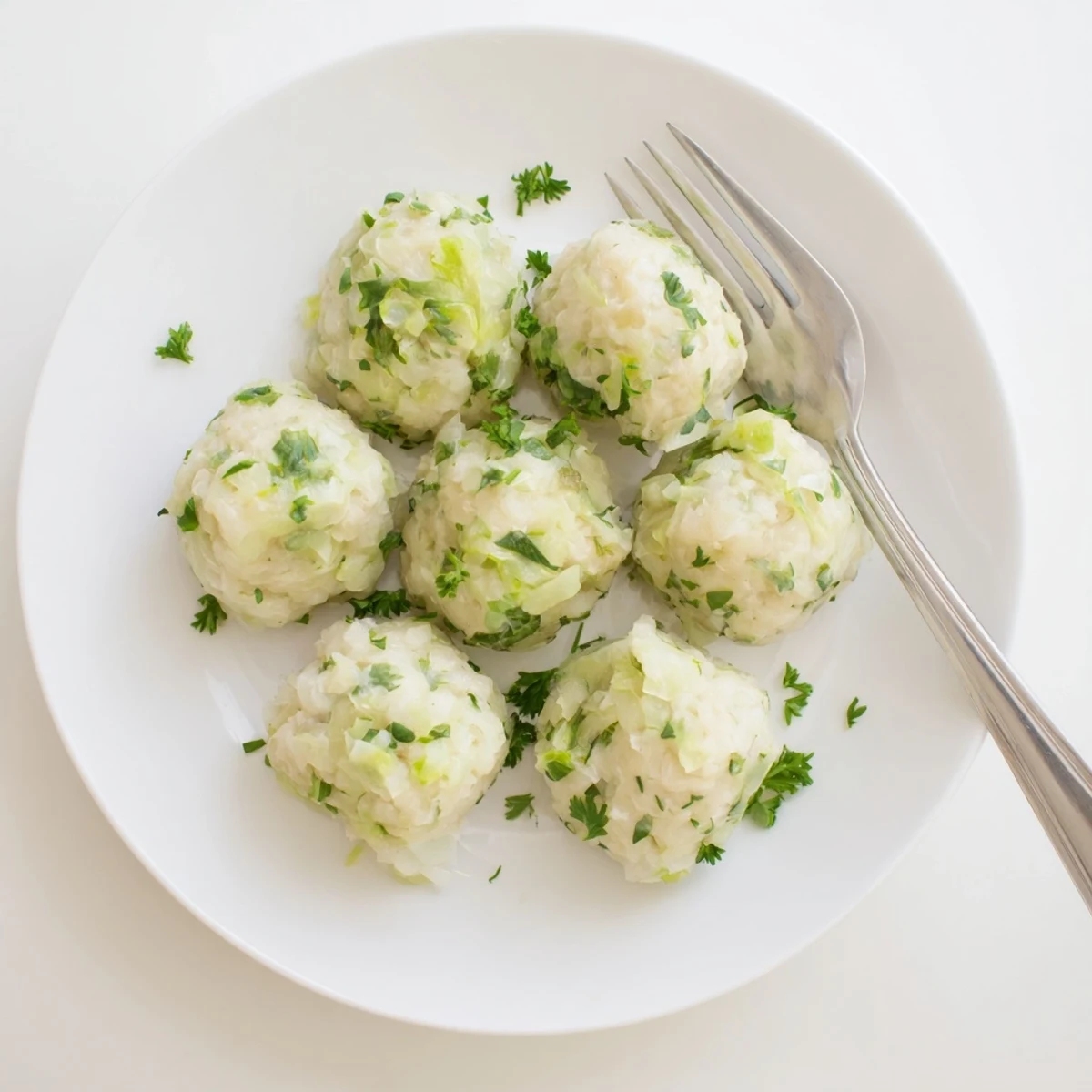 Tender German Cabbage Dumplings simmer in vegetable broth, steam rising from fluffy dumplings served with melted butter.