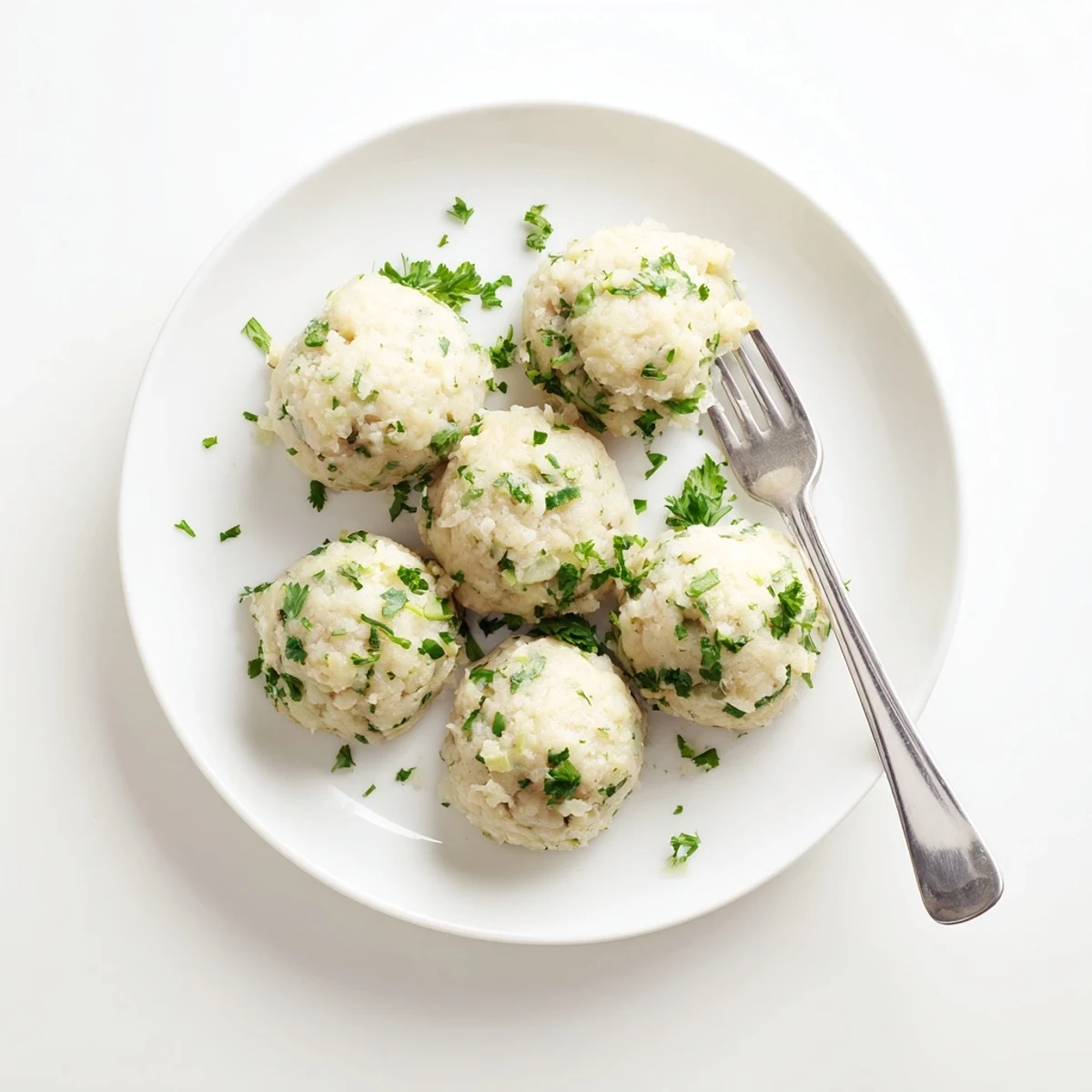 Golden German Cabbage Dumplings sit on a plate with fresh herbs, capturing the aroma of nutmeg and savory cabbage.