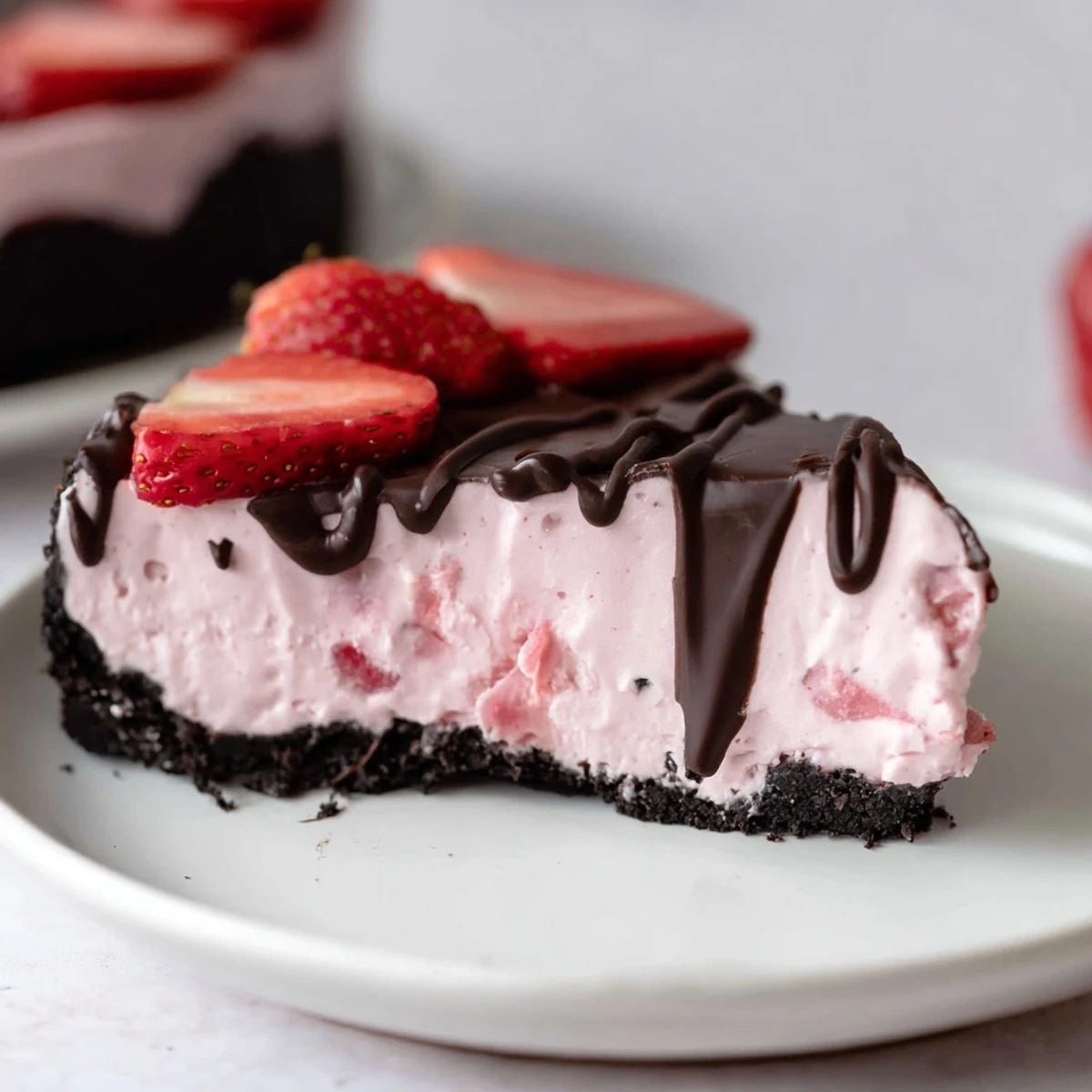 A whole Chocolate Covered Strawberry Cheesecake with chocolate cookie crust and glossy ganache topped with fresh strawberries.