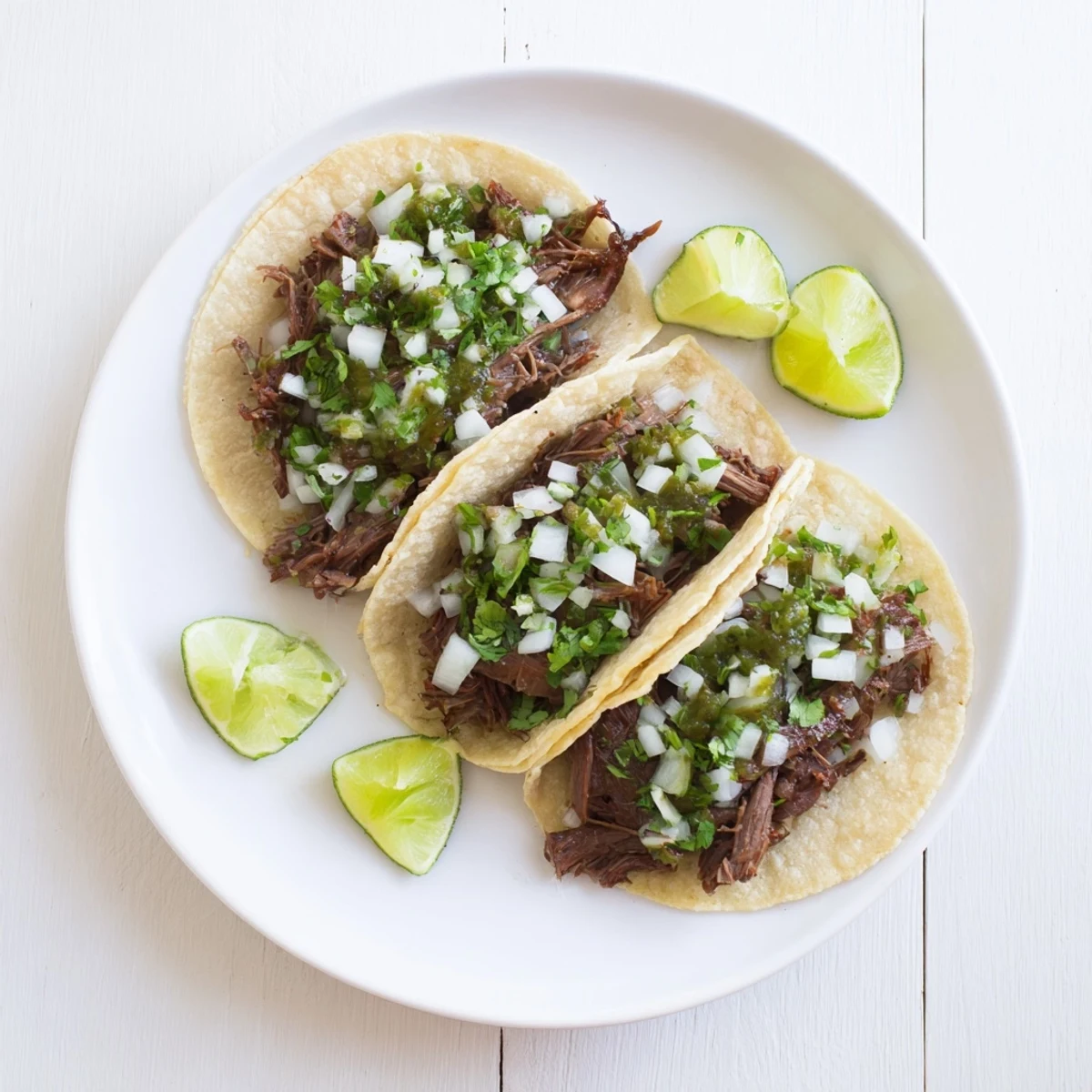 Steaming shredded Beef Cheek Tacos filled with tender meat and fresh cilantro on warm corn tortillas.