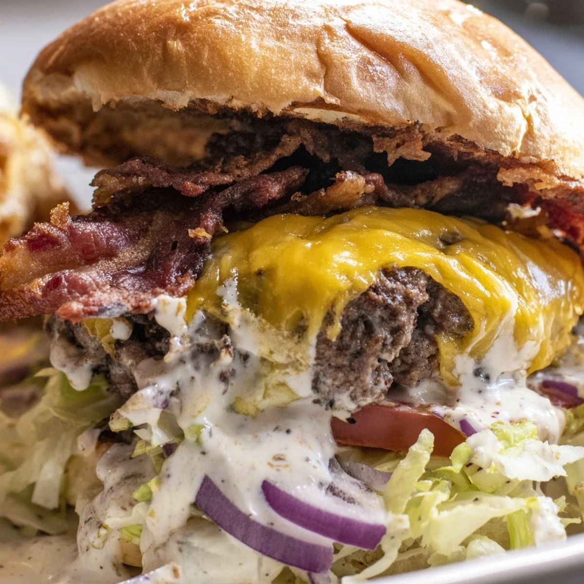 Ultimate crack burger stacked high with bacon cheese and creamy white sauce topping