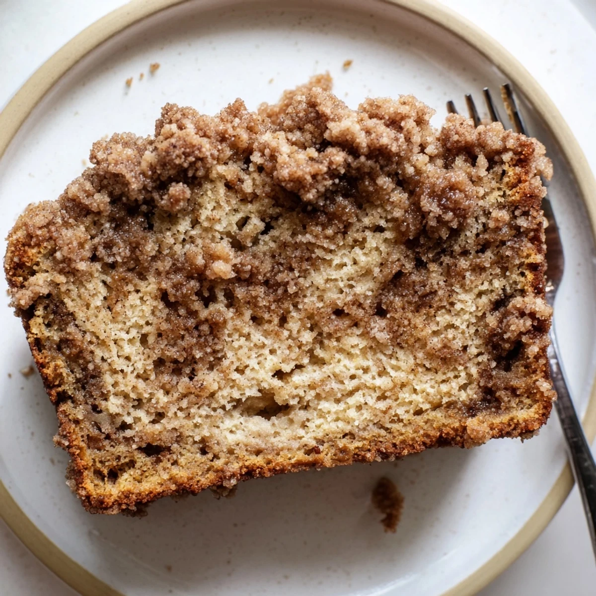 Golden cinnamon crumb banana bread loaf topped with buttery brown sugar streusel topping