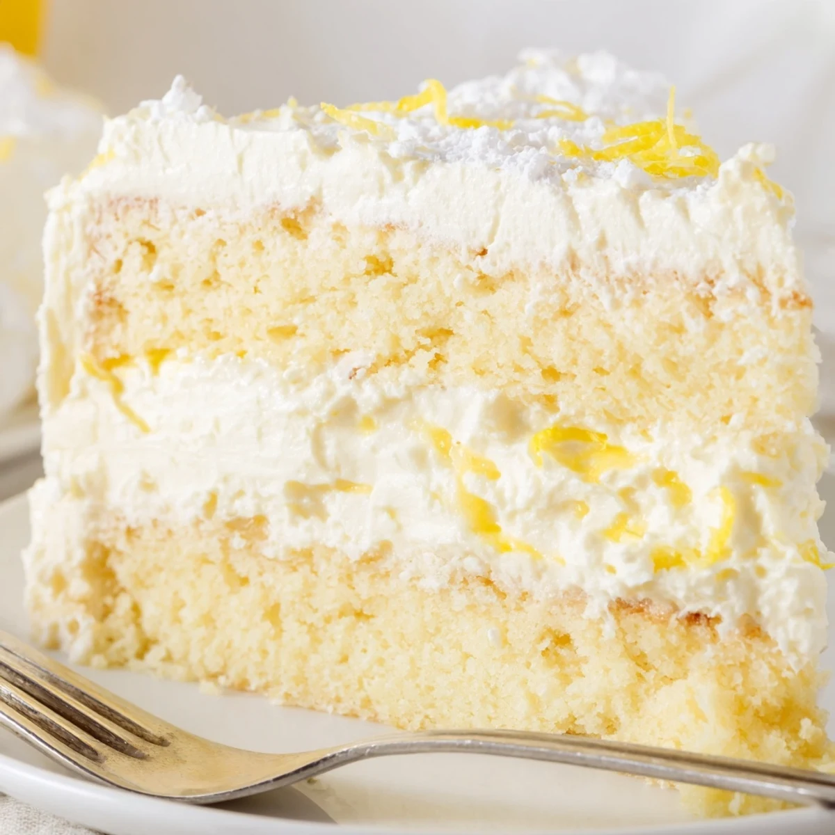 Golden Italian lemon cream cake with fluffy layers and zesty mascarpone filling dusted in powdered sugar