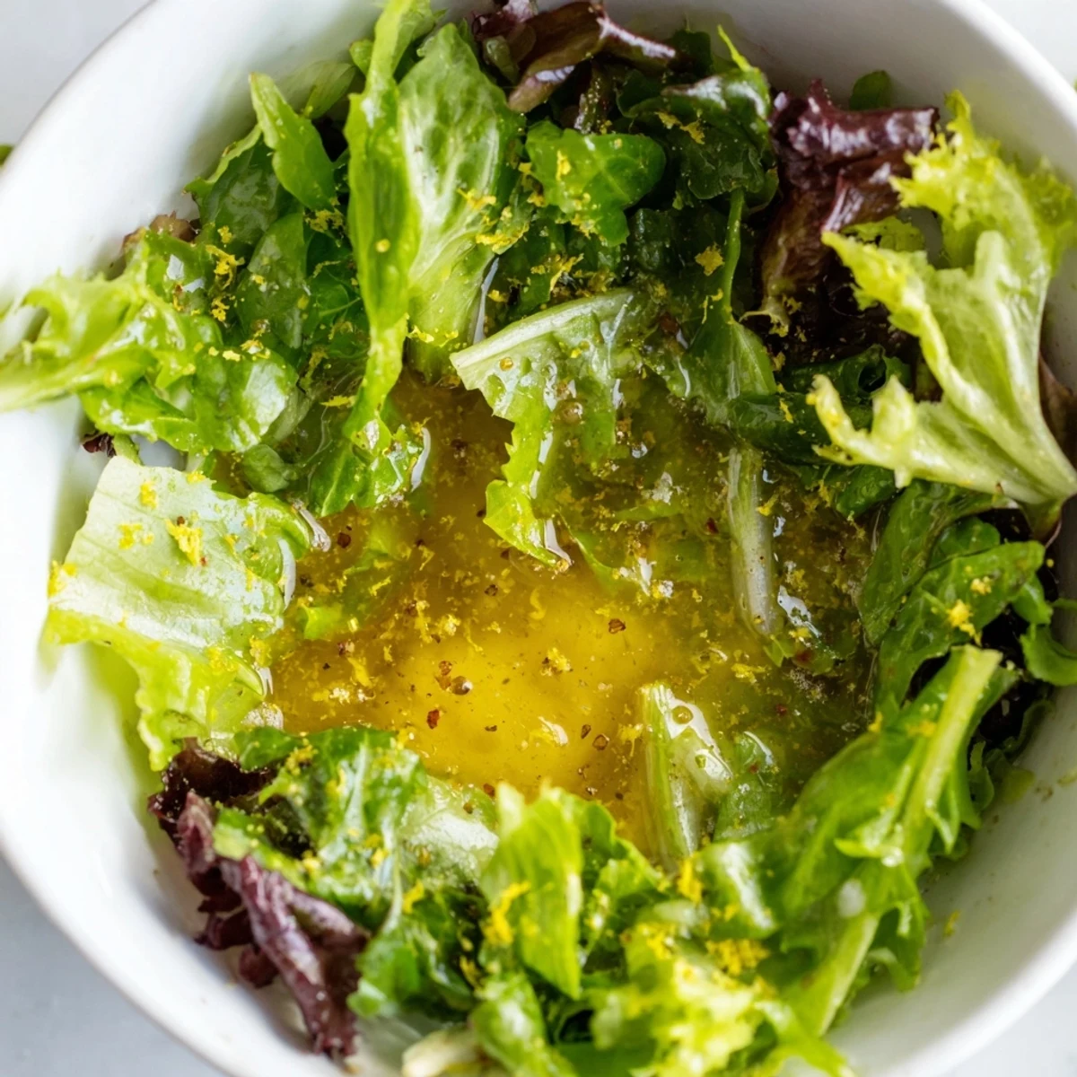 Smooth honey lemon vinaigrette coating crisp garden salad with cherry tomatoes and cucumber wedges