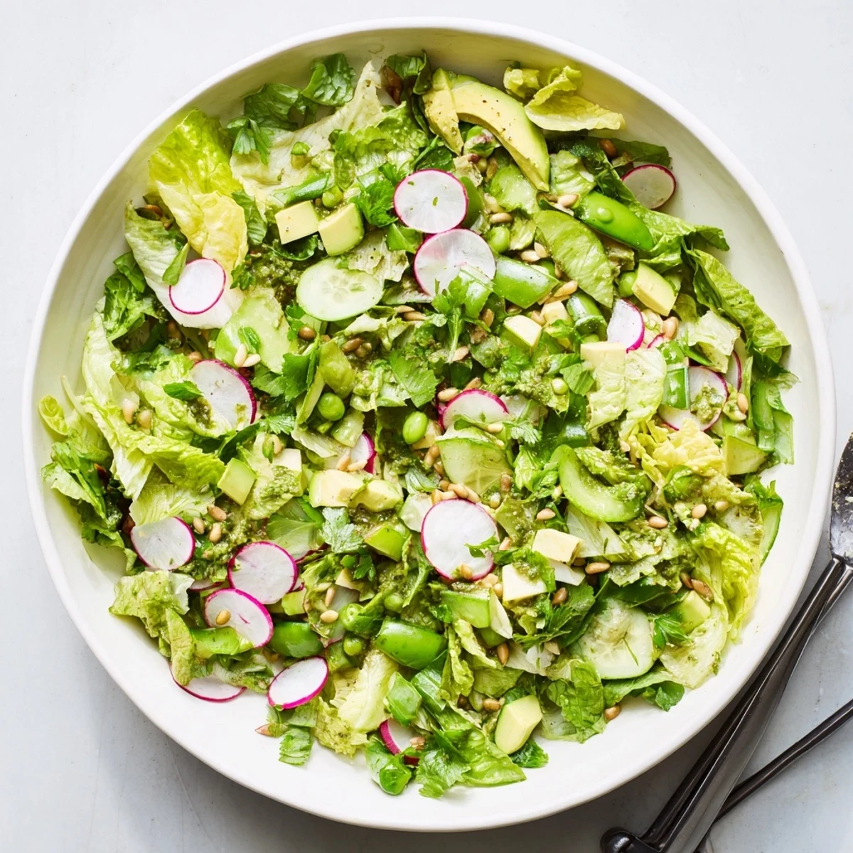 Fresh Green Goddess salad bowl with crisp lettuce, avocado, cucumber, and vibrant green dressing
