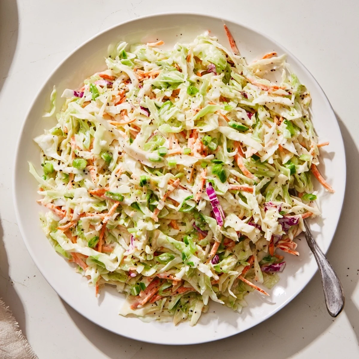 Refreshing easy creamy coleslaw piled high showing vibrant red and green cabbage shreds with glossy coating