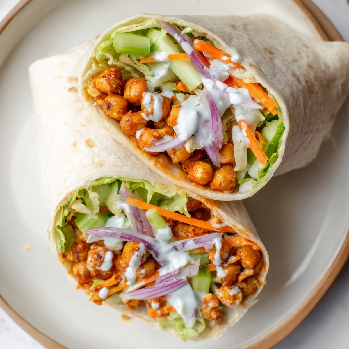 Golden buffalo chickpea wraps filled with crisp lettuce, crunchy celery, and creamy ranch dressing