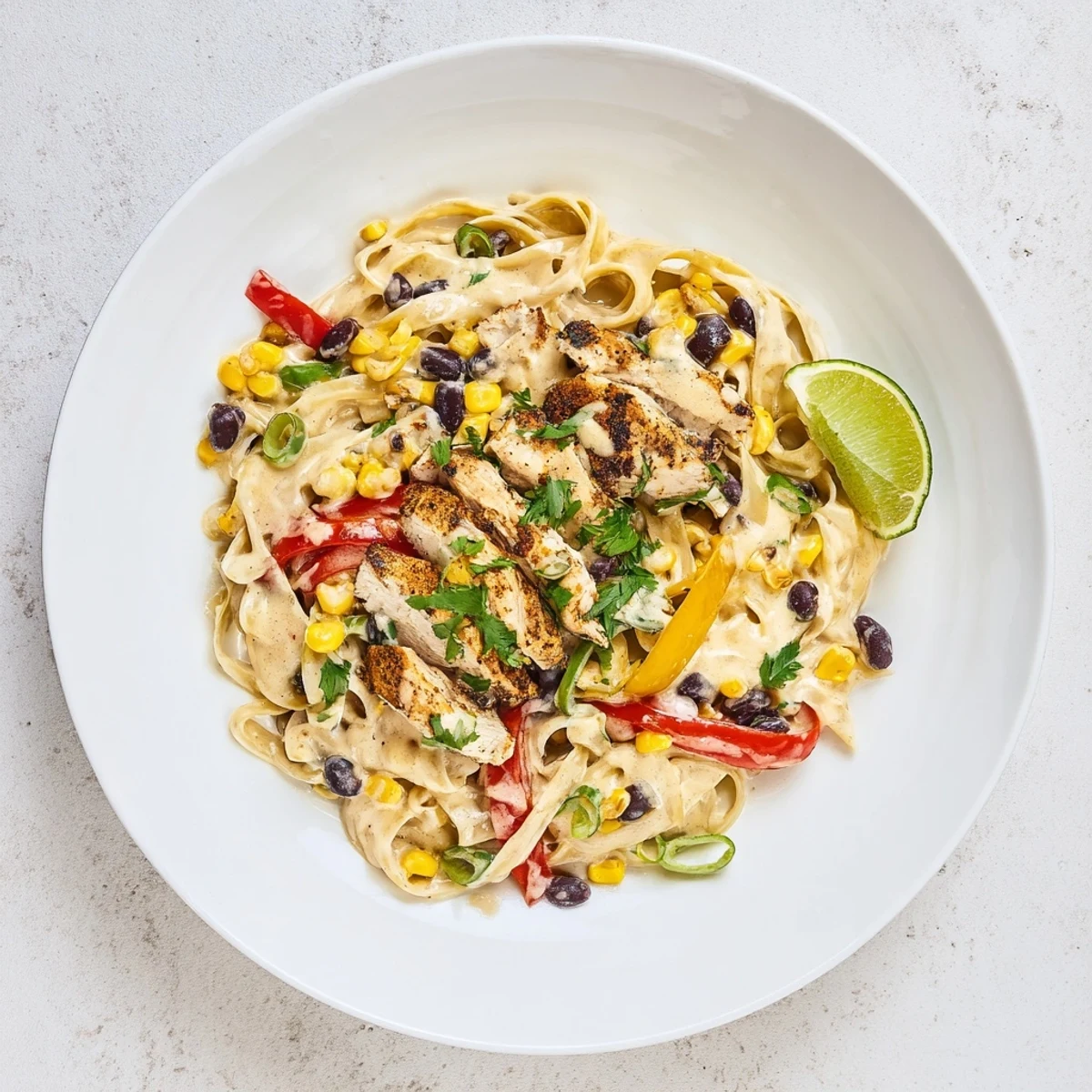 Creamy Southwest chicken Alfredo pasta with sliced chicken breast and colorful bell peppers in a rich white sauce
