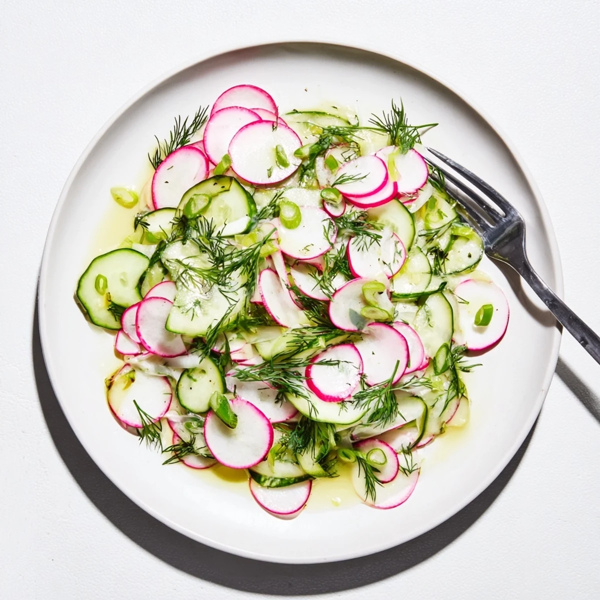 Crisp sliced radishes and cucumbers tossed in tangy lemon dressing on a rustic wooden table