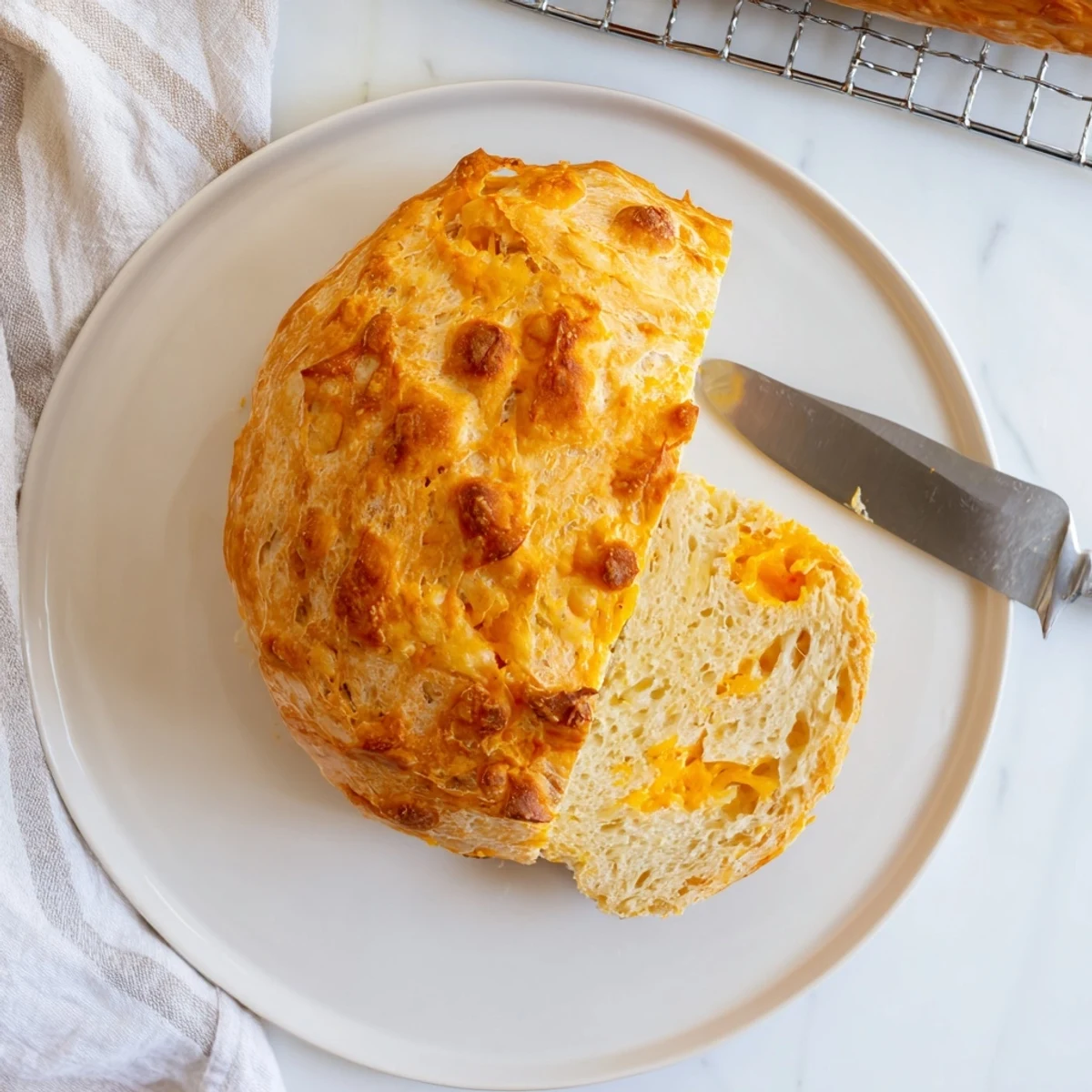 Freshly sliced no knead cheddar bread on a wooden board with perfect texture