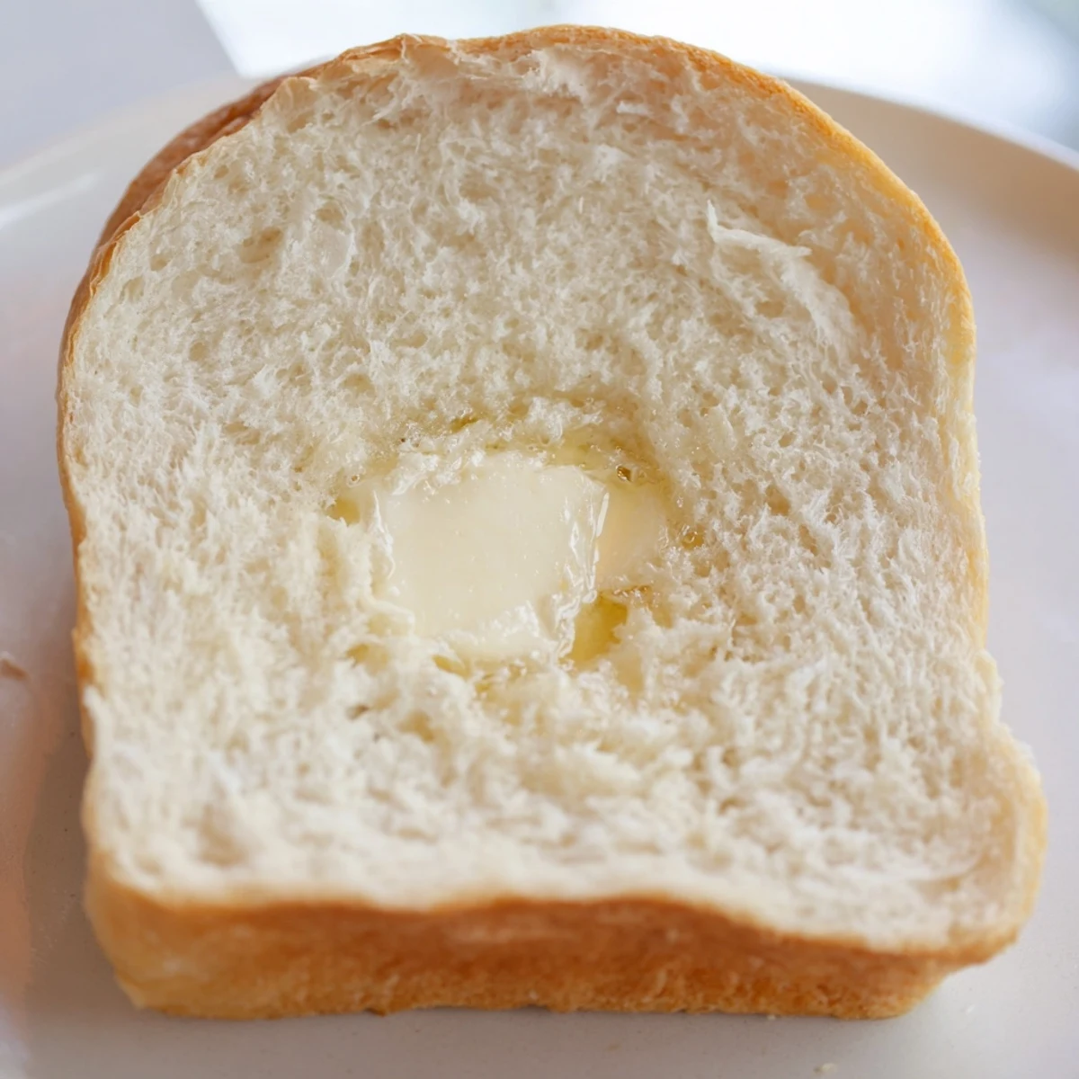 Golden brown homemade Amish white bread loaf with soft interior perfect for sandwiches