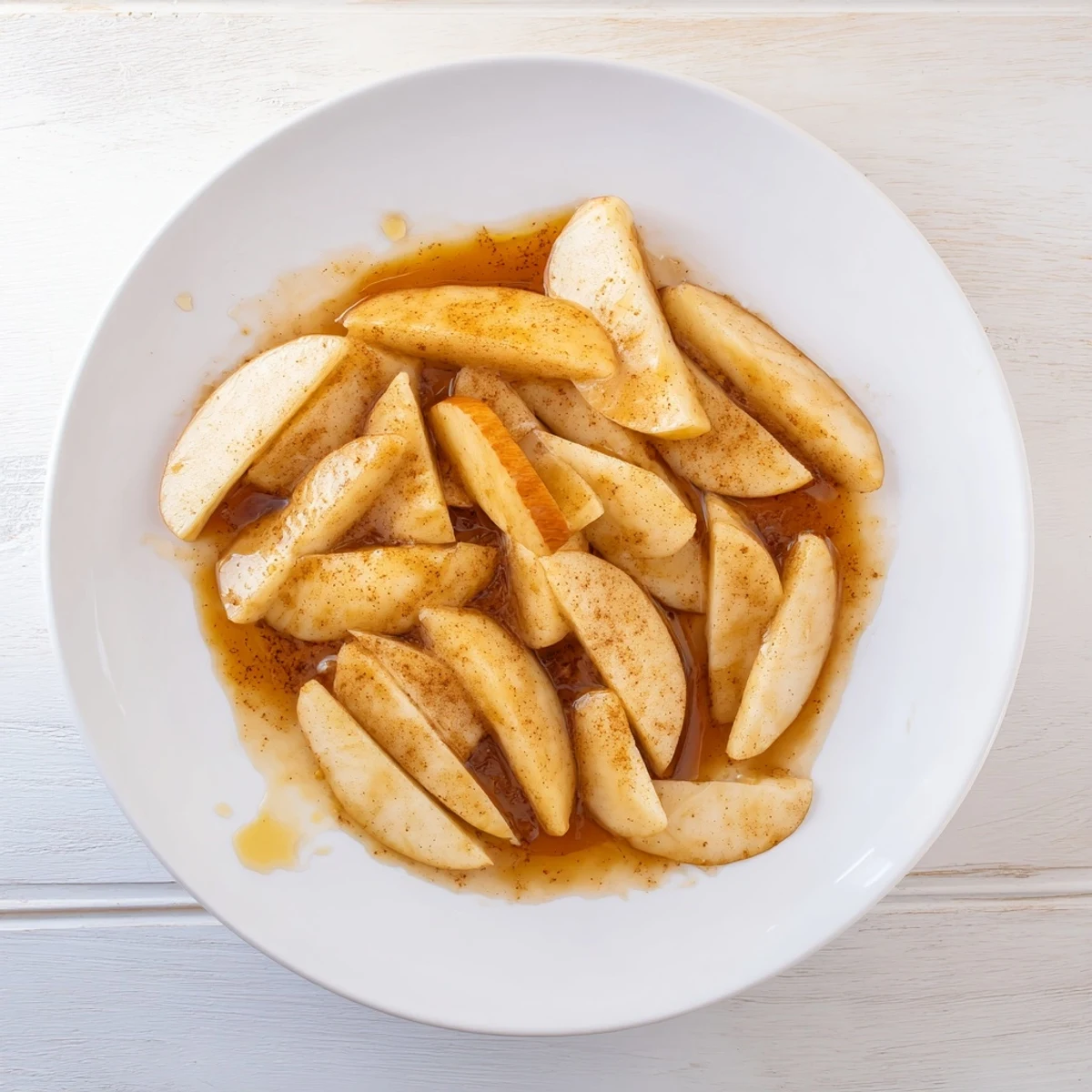 Warm cinnamon apples arranged on a rustic wooden board with vanilla ice cream scoop