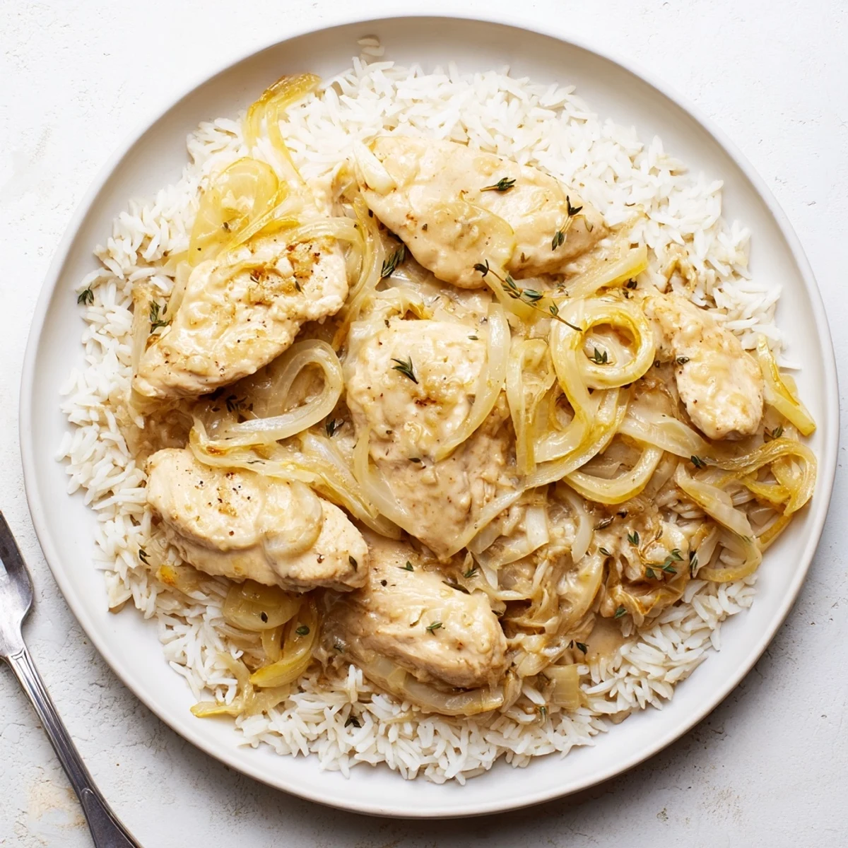Creamy French onion chicken rice bubbling in a Dutch oven with rich sauce and shredded cheese melted over tender chicken pieces