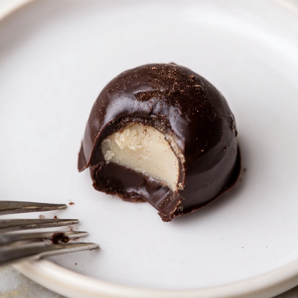 Hand rolled Dark Chocolate Eggnog Truffles on parchment, rich, silky, cooling