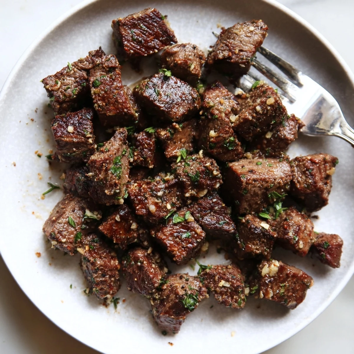 Garlic Butter Steak Bites sizzling in cast iron, glossy butter, fresh parsley garnish