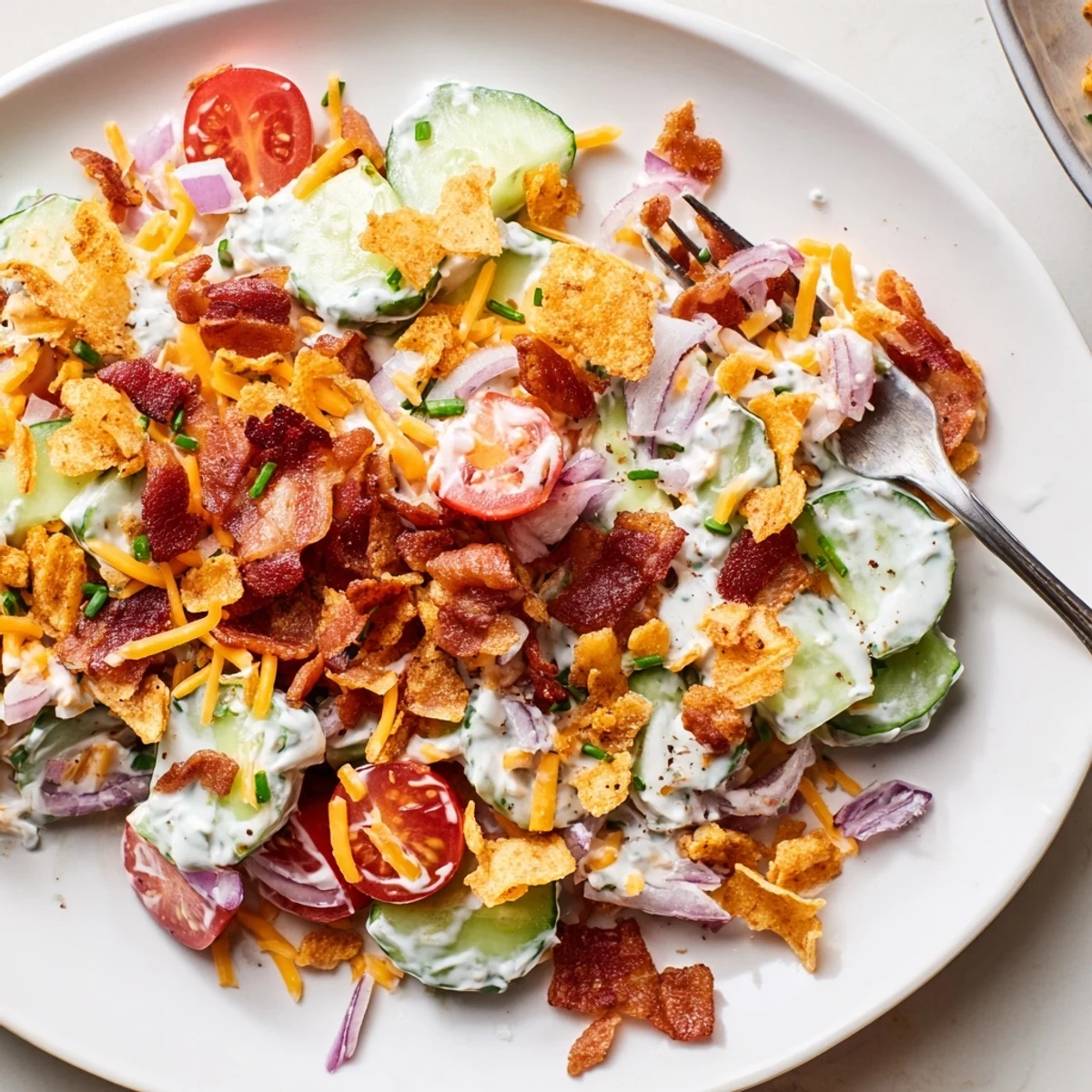 Cucumber Ranch Crack Salad with crispy bacon, cheddar, and crunchy chip topping.