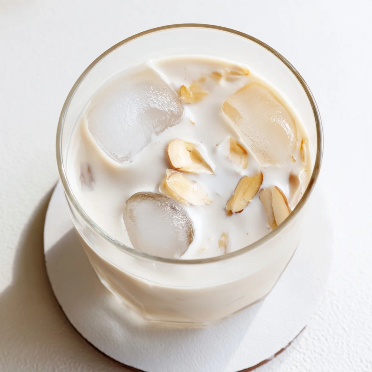 Golden roasted almond milk drink with cream swirl garnished with almond slivers and cinnamon