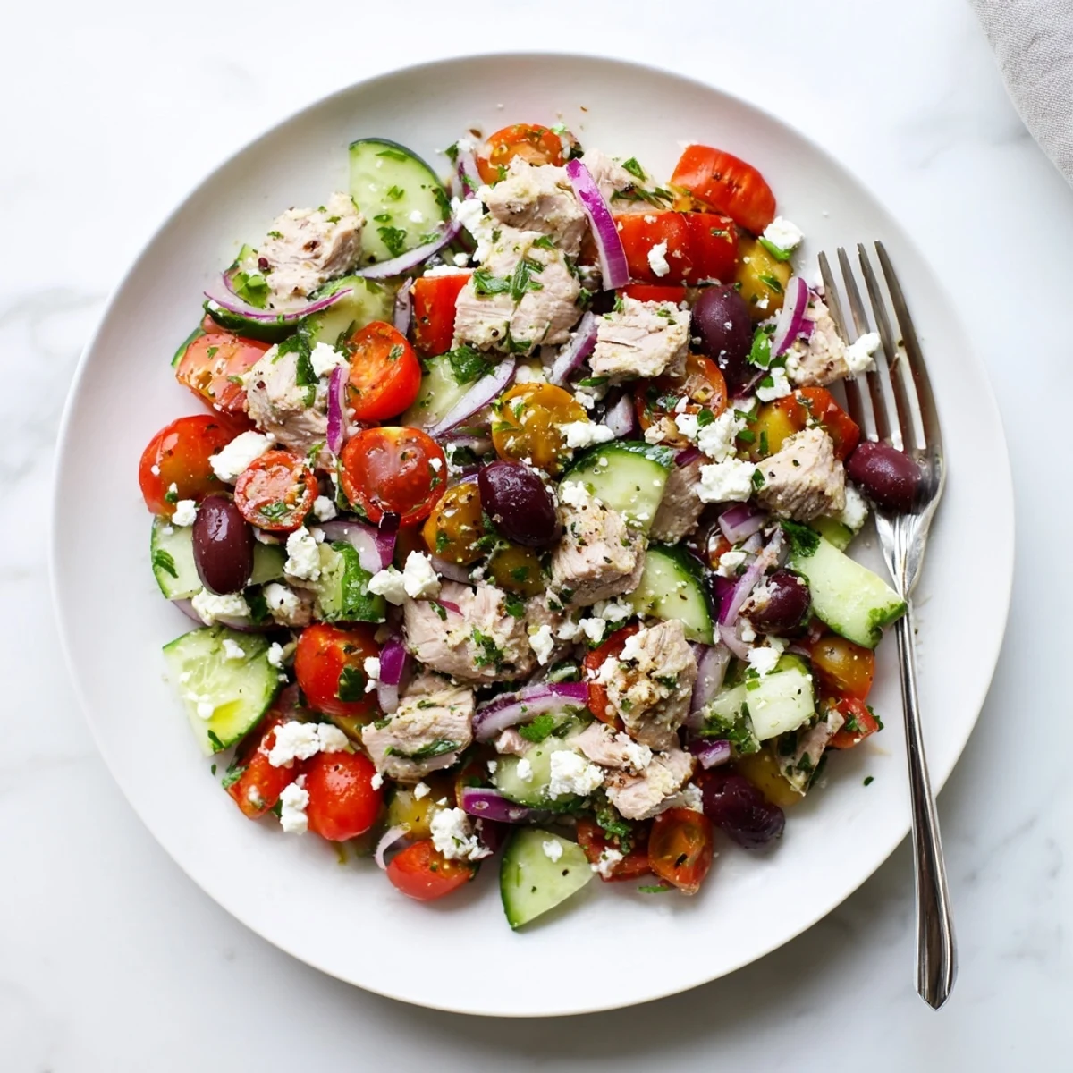 Vibrant Mediterranean tuna salad bowl with fresh vegetables, olives, and tangy lemon dressing