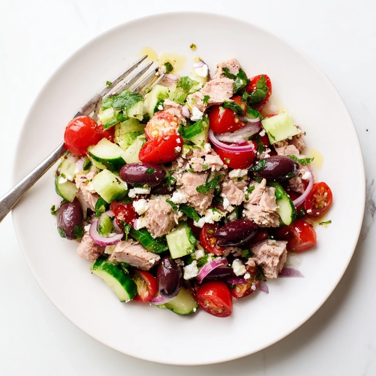 Colorful Mediterranean tuna salad plated with cherry tomatoes, red onion, and zesty olive oil dressing