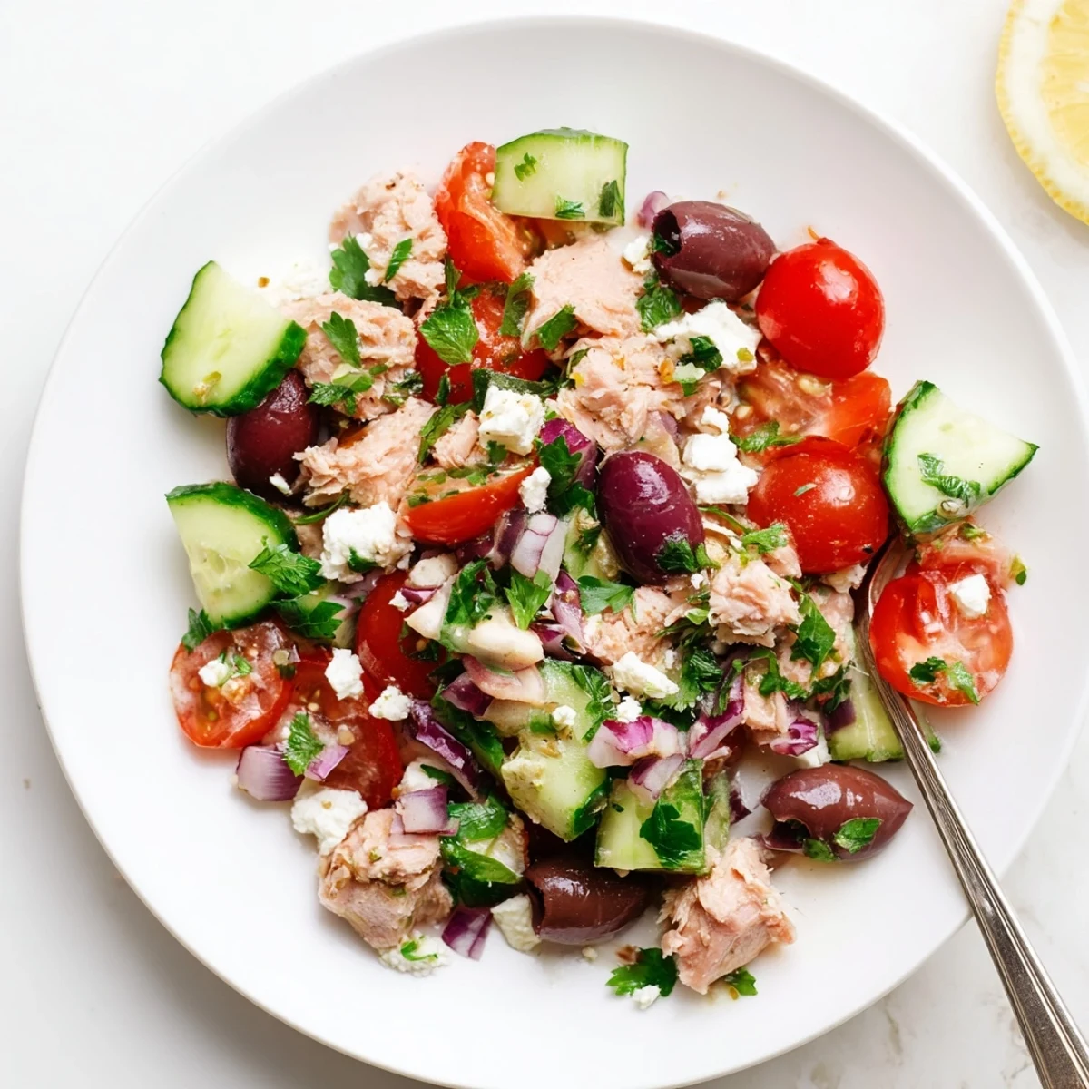 Protein-packed Mediterranean tuna salad featuring crisp cucumbers, tomatoes, and crumbled feta cheese topping