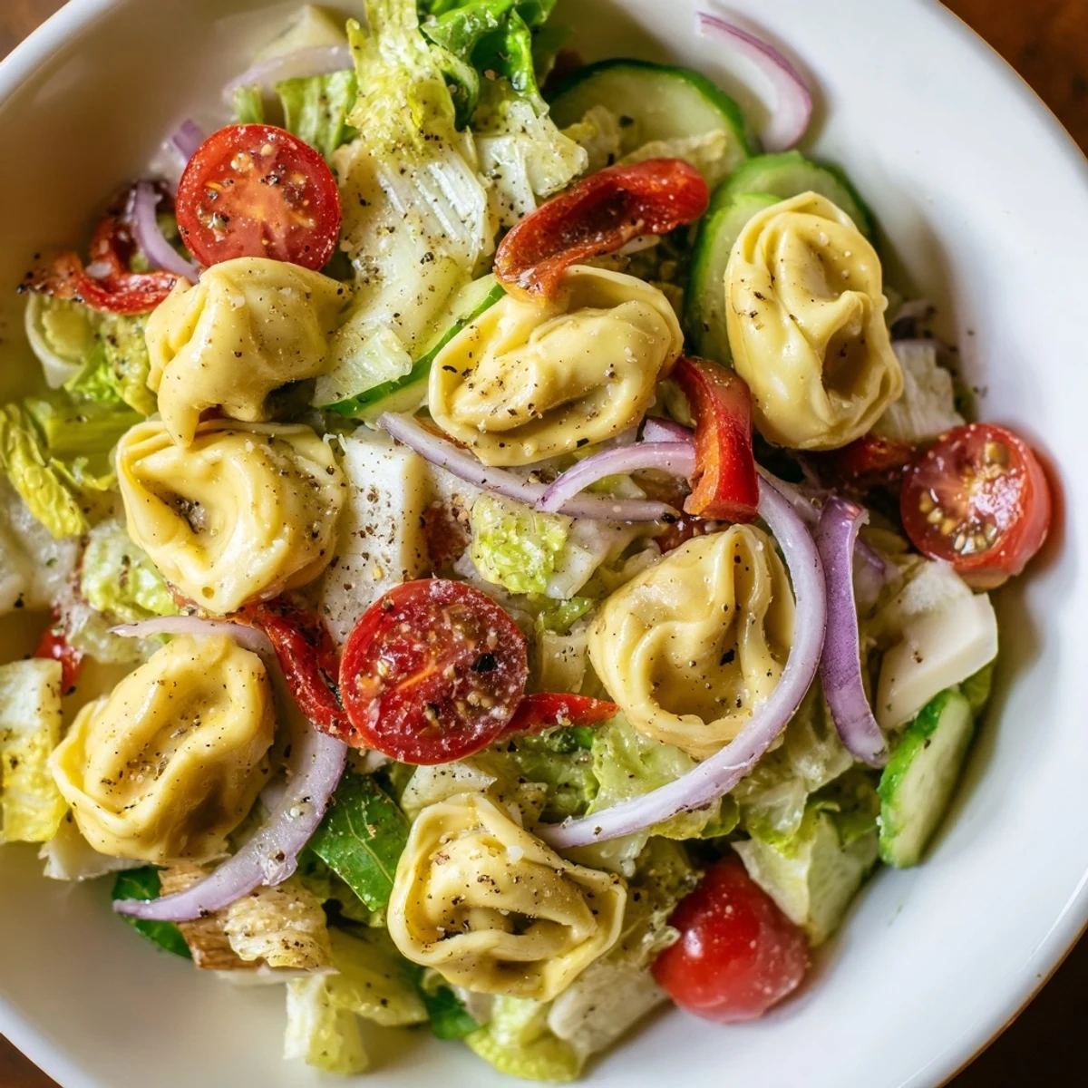 Colorful bowl of fresh grinder tortellini salad recipe with cherry tomatoes, provolone, and crisp vegetables tossed in zesty Italian dressing