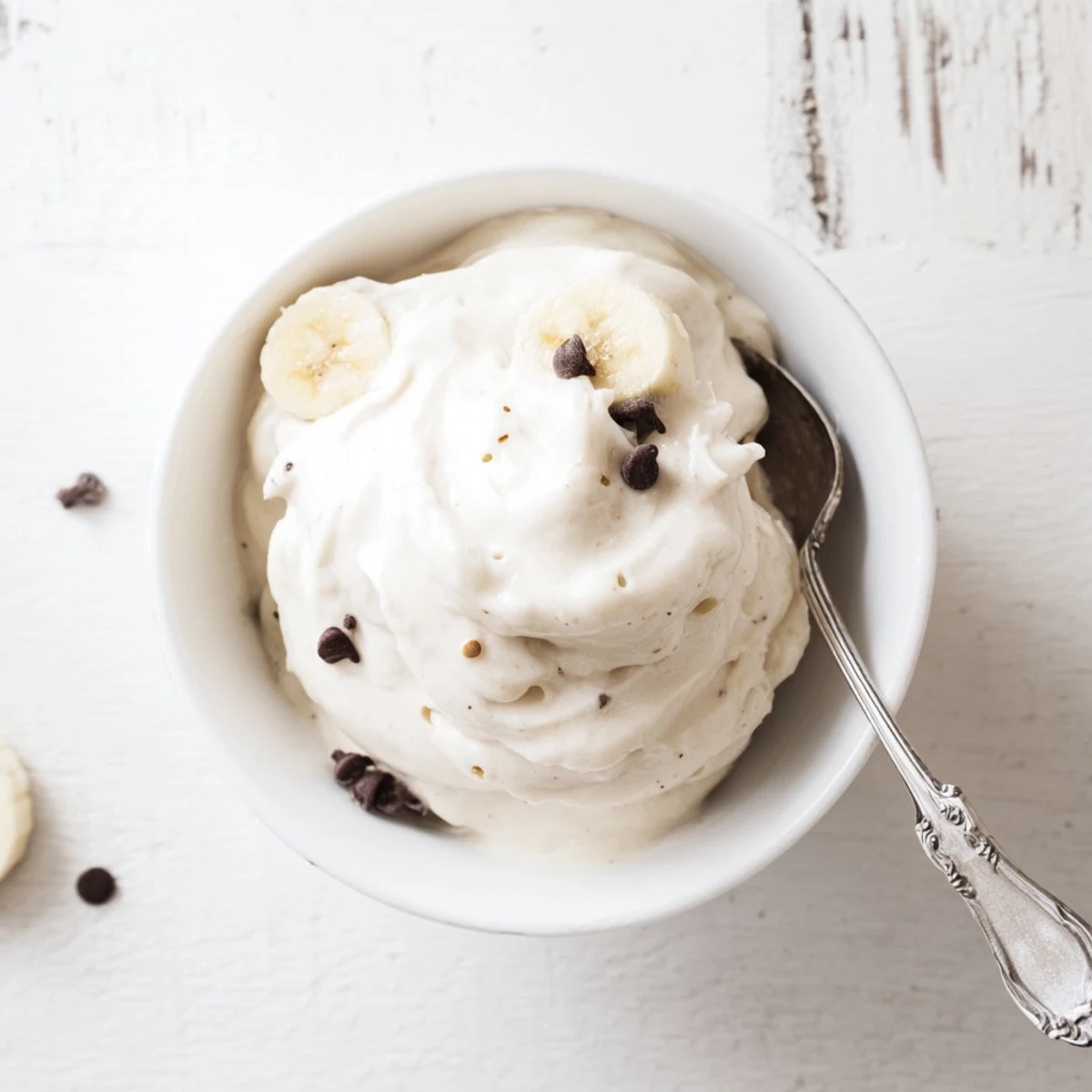 Creamy banana nice cream scooped into bowls with fresh banana slices and a drizzle of honey