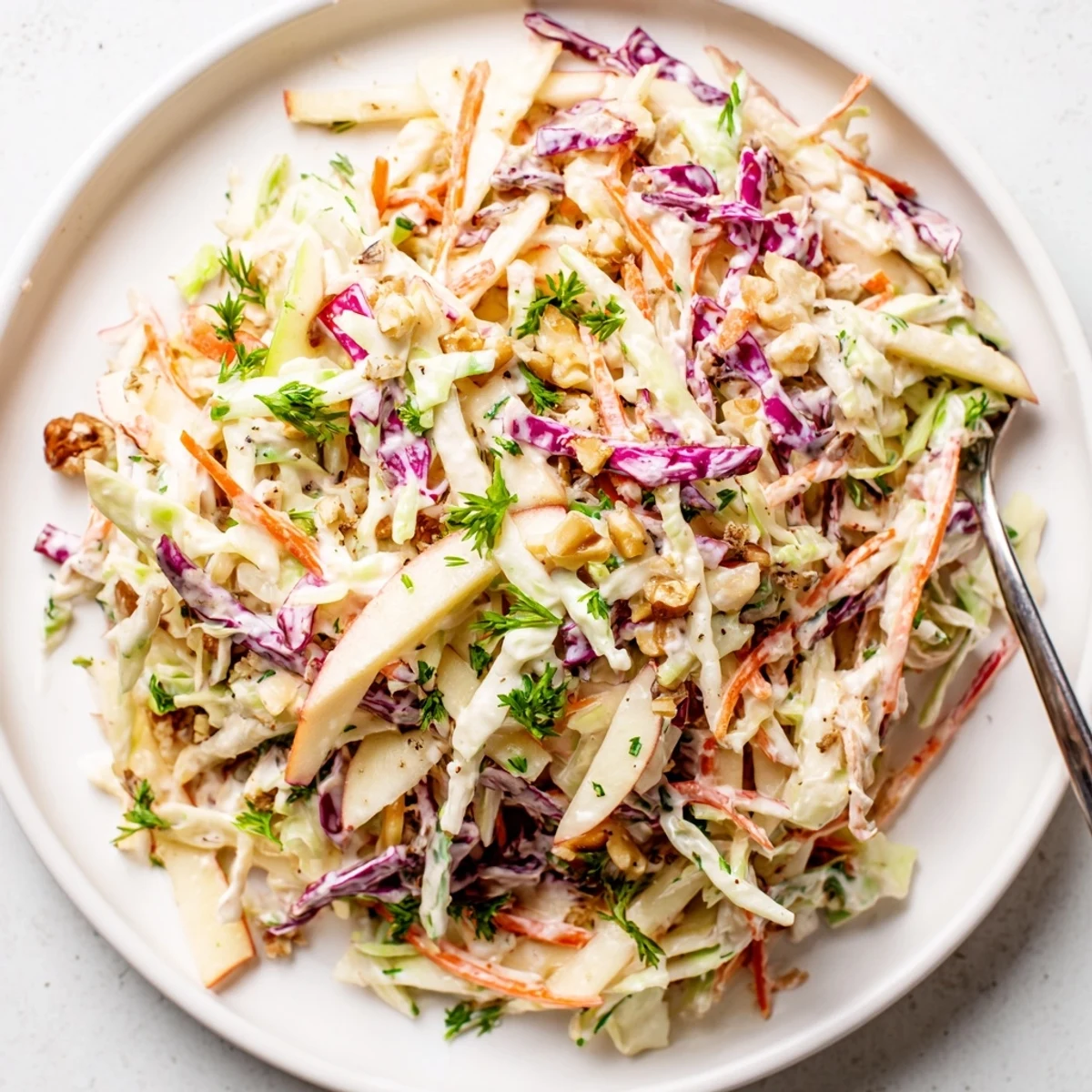 Apple Coleslaw with shredded cabbage and julienned apples, creamy tangy dressing.