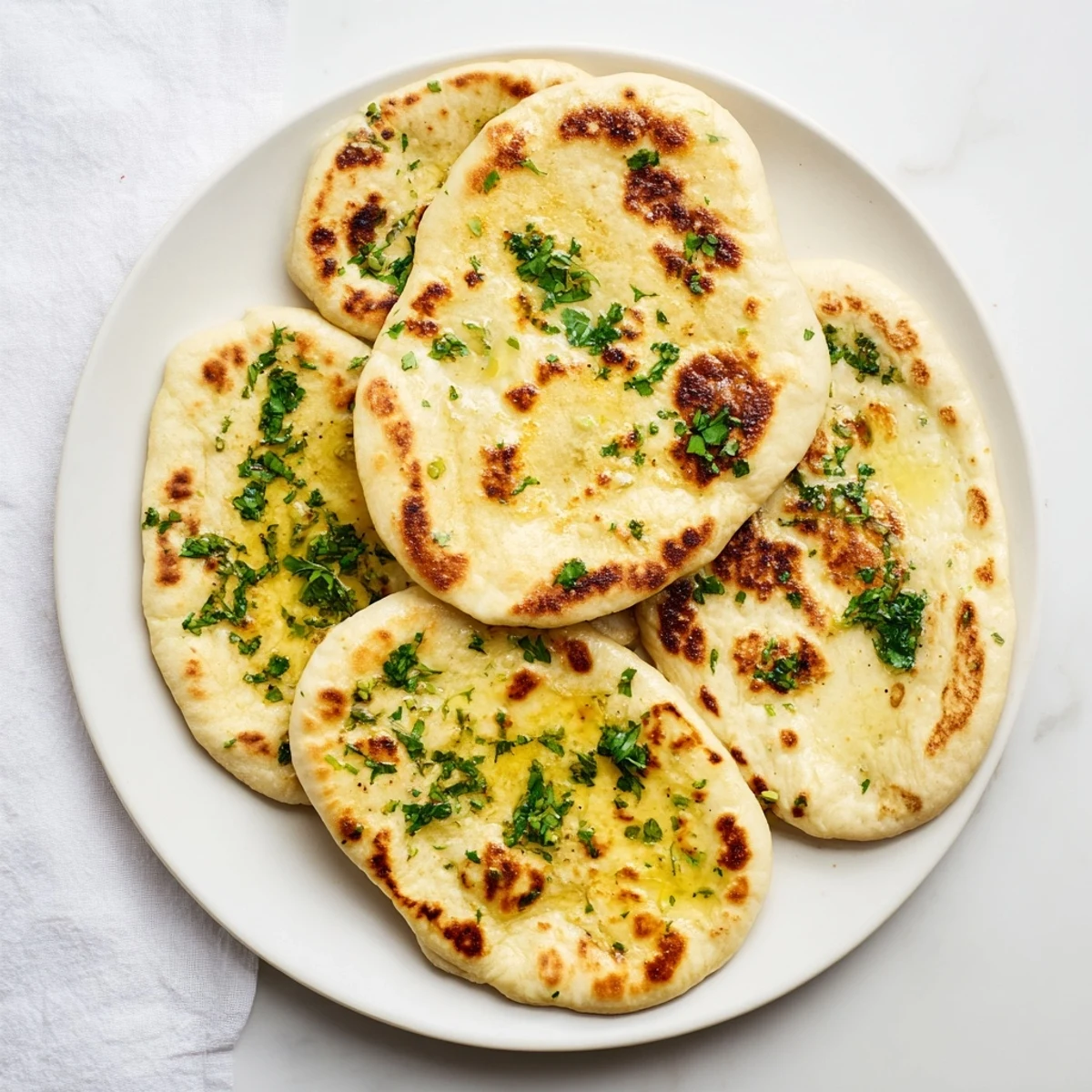 Golden brown sourdough discard soft naan brushed with melted butter and fresh cilantro