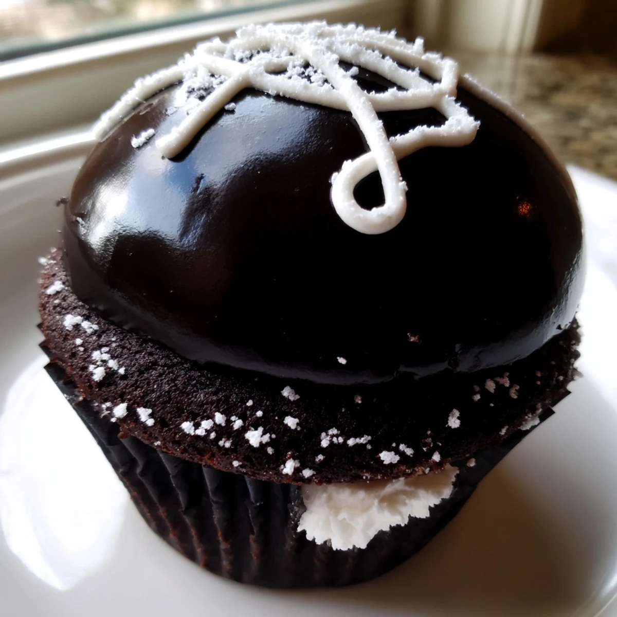 Homemade Hostess Cupcakes topped with glossy chocolate ganache and signature white swirls
