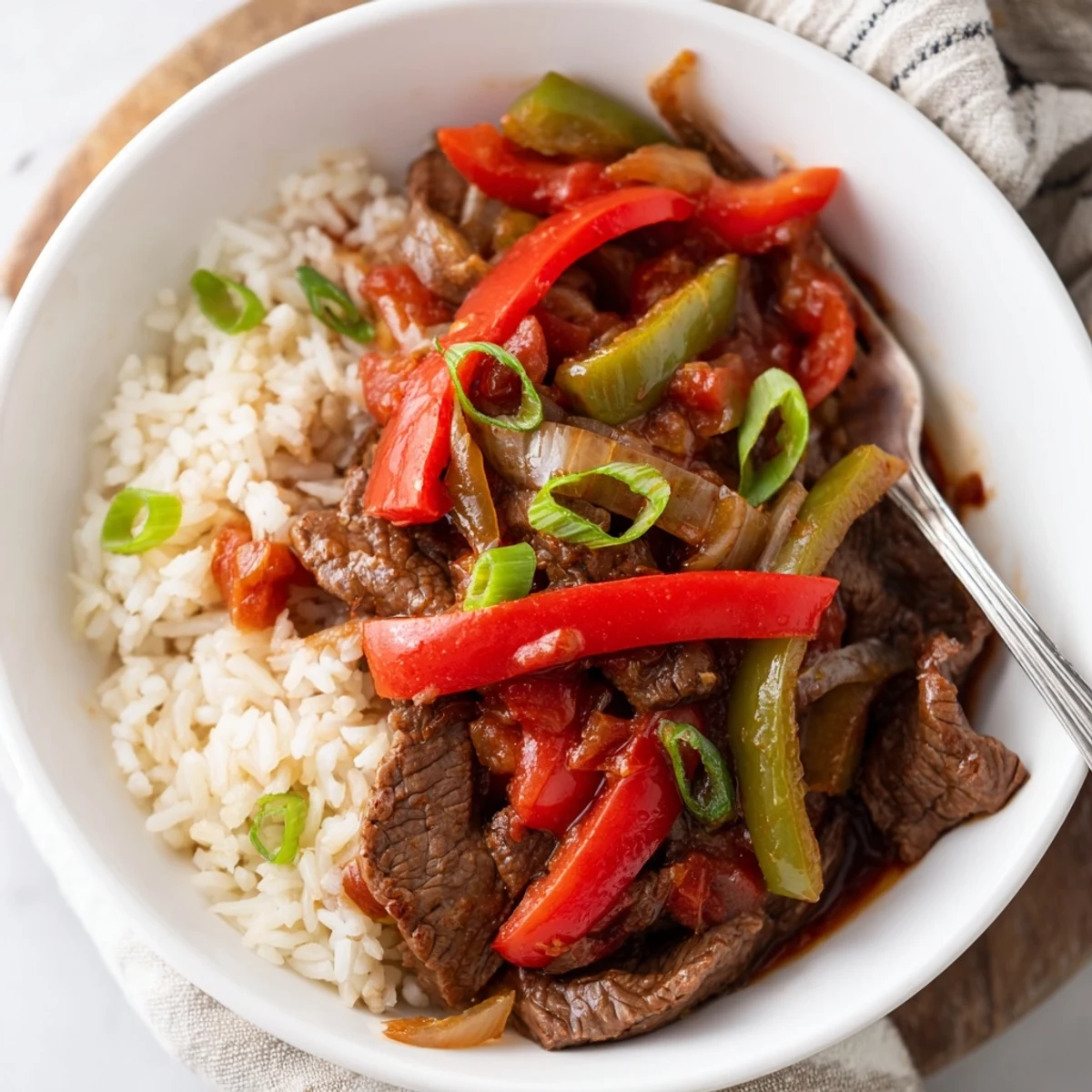Glossy Slow Cooker Pepper Steak featuring colorful sliced peppers and onions in rich brown gravy