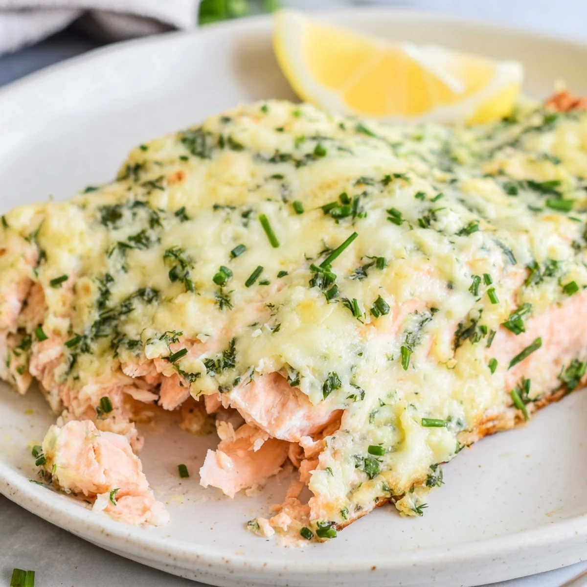 Golden baked salmon crusted with creamy Boursin cheese served alongside fresh lemon wedges