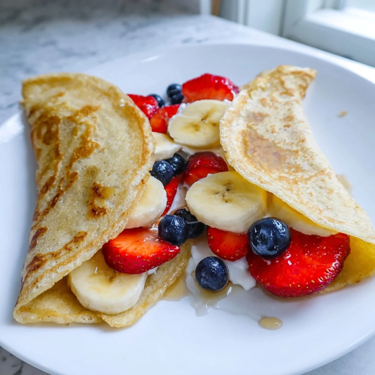Fluffy pancake tacos filled with fresh strawberries and drizzled maple syrup