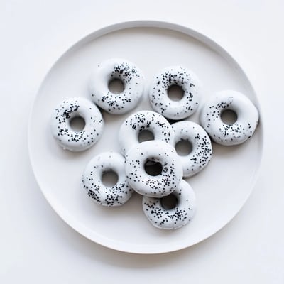 Warm Black Sesame Mochi Donuts cooling on a wire rack, showcasing their golden-brown edges and chewy texture against a cozy kitchen backdrop.