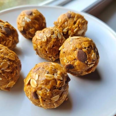 Creamy no bake pumpkin protein balls studded with chocolate chips in a chilled bowl