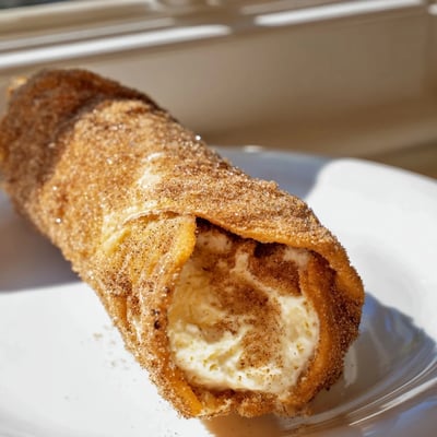Creamy cheesecake chimichangas fresh from the fryer dusted with warm cinnamon sugar