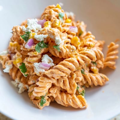 Vibrant elote pasta salad loaded with sweet corn, zesty lime, and smoked paprika dressing